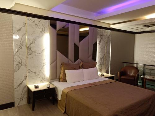 台中市心圆精致汽车旅馆的酒店客房带一张床和紫色照明