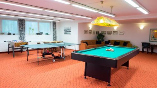 施伦斯蒙特约拉诺娃酒店的客厅配有两张乒乓球桌
