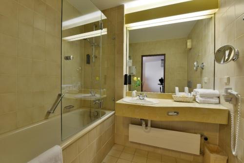 莱茵河畔威尔贝塞尔维尔阿姆雷恩旅店的一间带水槽、浴缸和镜子的浴室