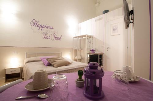 圣贝内代托-德尔特龙托帕特里希奥住宿加早餐酒店的一间卧室配有一张床和一张带紫色桌布的桌子