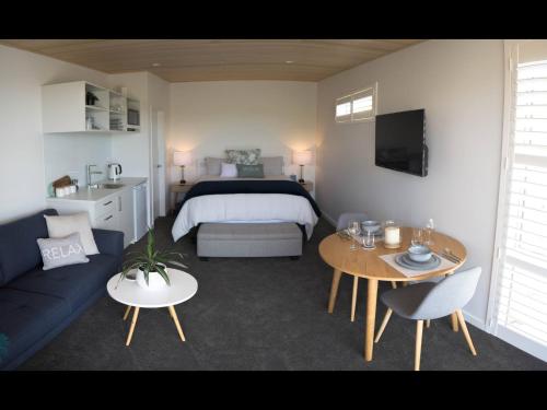 纳尔逊Wake Field Views的客房设有床、沙发和桌子。