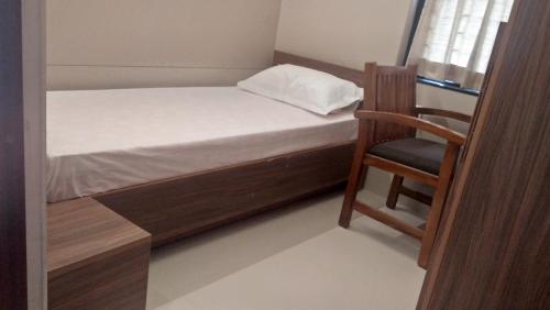 德里久尔LEMON RESIDENCY By Chungath的一间小卧室,配有一张床和一把椅子