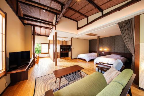 伊豆之国市Yumeguri no Yado Yoshiharu的酒店客房,设有两张床和一张沙发