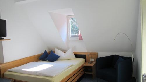 海德堡海德堡安拉格酒店的一间小卧室,配有一张床和一把椅子
