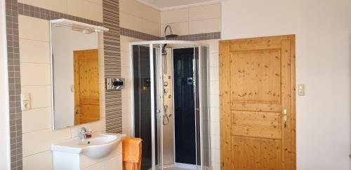 圣科卡瑟林奥夫胡伯霍夫阿尔门兰德公寓的一间带水槽、淋浴和镜子的浴室