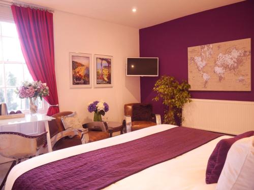 GuestlingGuestling Hall Hotel的一间卧室配有一张紫色墙壁的床和一张桌子