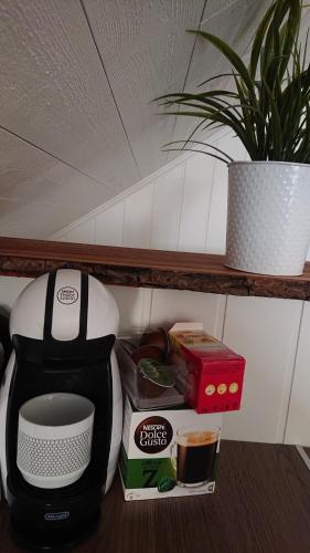 博伦厄Myntloftet Borlänge med inglasad bubbelbad的一个带咖啡壶和其他厨房用品的架子