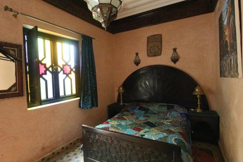 马拉喀什RIAD MAKENE MOUCHKILL的一间卧室设有一张床和一个窗口