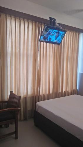 德里久尔LEMON RESIDENCY By Chungath的卧室配有一张床,墙上配有电视。