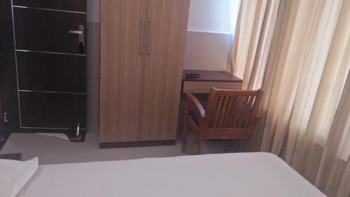 德里久尔LEMON RESIDENCY By Chungath的一间卧室配有一张床、一张桌子和一把椅子