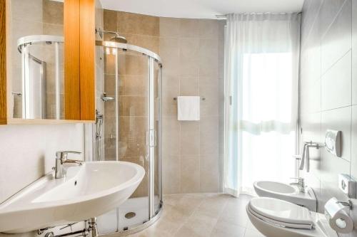 格巴格南特莫纳斯特尔圣马蒂诺品质酒店的一间带水槽、两个卫生间和淋浴的浴室