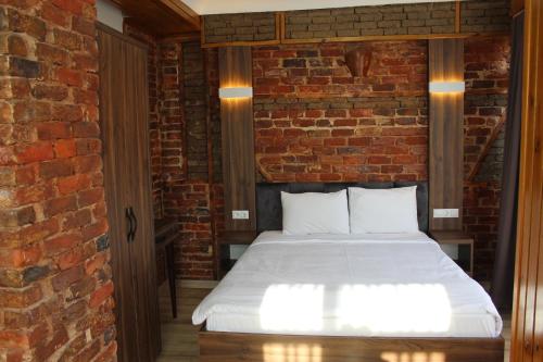 伊斯坦布尔Han Suite Hotel的砖墙房间的一个床位