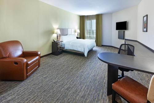 休斯顿Candlewood Suites Houston - Spring, an IHG Hotel的酒店客房,配有一张床、一张桌子和椅子