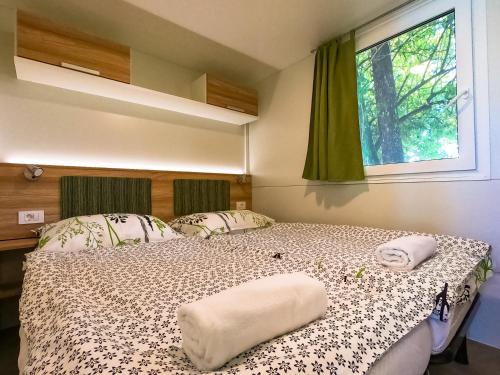 梅特利卡Holiday resort & camping Bela krajina - river Kolpa的一间卧室设有一张床和一个窗口