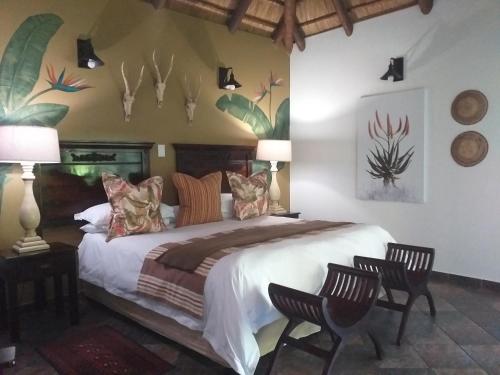 圣卢西亚阿非利加旅馆的一间卧室配有一张大床和两把椅子
