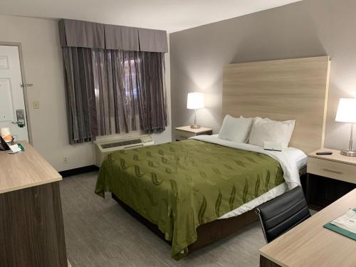 埃尔帕索机场东品质酒店的酒店客房,配有一张带绿床罩的床