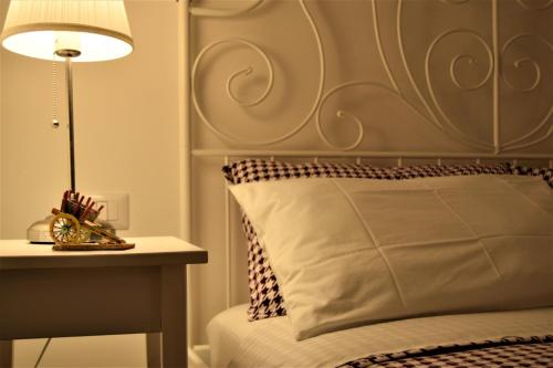锡拉库扎IL MORO holiday home的一张带床头板的床和一张带台灯的桌子