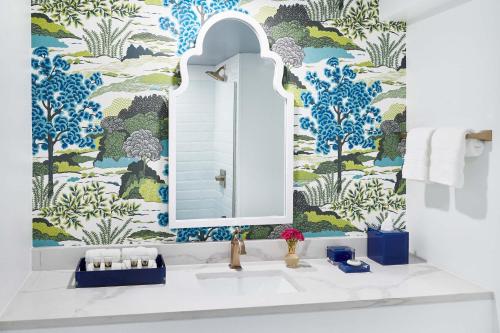 圣西蒙斯岛Hotel Simone的浴室配有水槽和蓝白色壁纸。