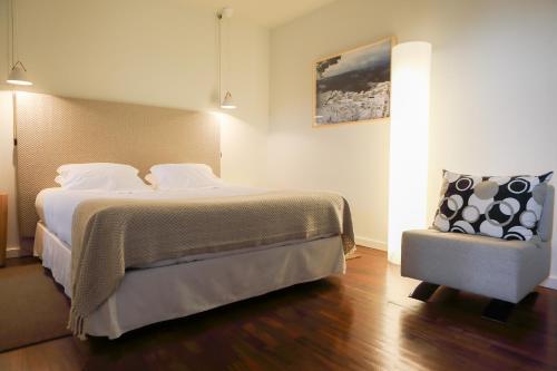 塞亚卡萨斯多索伊托公寓的一间卧室配有一张大床和一把椅子