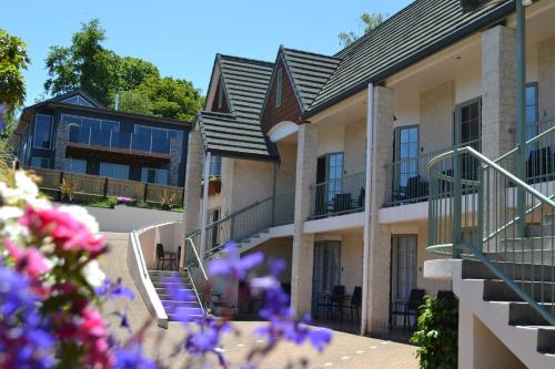 陶波殖民地汽车旅馆的前方有楼梯和紫色花的建筑