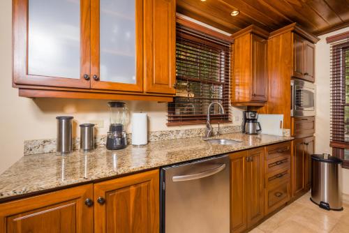 塔马林多Jet Luxury at Langosta Beach Resort & Villas的一个带木制橱柜和水槽的厨房