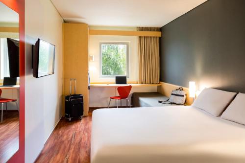 蒙特雷蒙特雷谷宜必思酒店的配有一张床、一张书桌和一扇窗户的酒店客房
