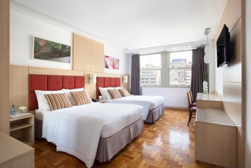 贝洛奥里藏特诺曼底酒店的酒店客房设有两张床和电视。