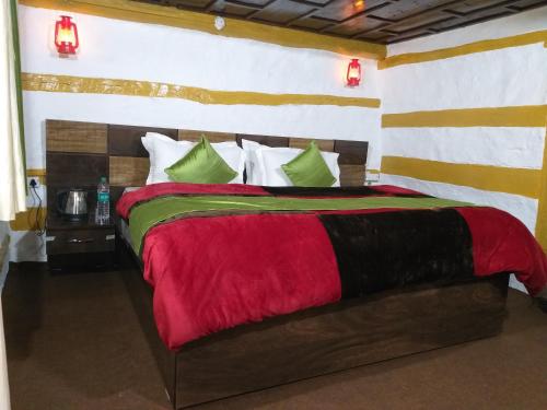 HarsilMountain Village Stay - Dharali Heights Harsil的一间卧室配有一张大床,铺有红色和绿色的床单。