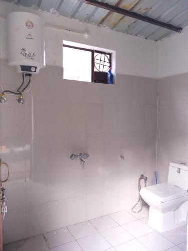 HarsilMountain Village Stay - Dharali Heights Harsil的白色的浴室设有卫生间和窗户。