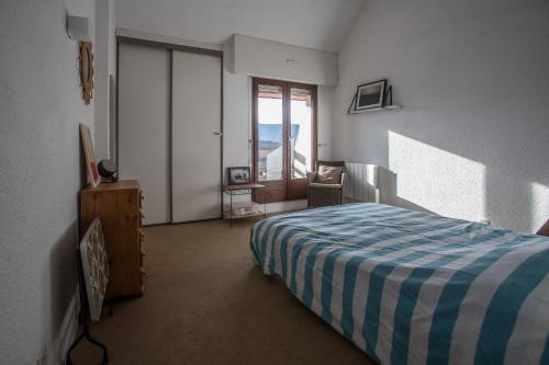 La PirrazAppartement Talloires vue lac et montagnes的一间卧室配有一张带蓝白色毯子的床