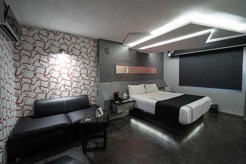 瓜达拉哈拉Kuboz Motor Hotel (Motel y Hotel)的一间卧室配有一张床和一张沙发