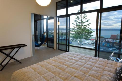 纳皮尔Vue Apartments的一间卧室配有一张床,享有海景