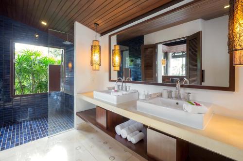 拉威海滩The Vijitt Resort Phuket - SHA Extra Plus的一间带两个盥洗盆和淋浴的浴室