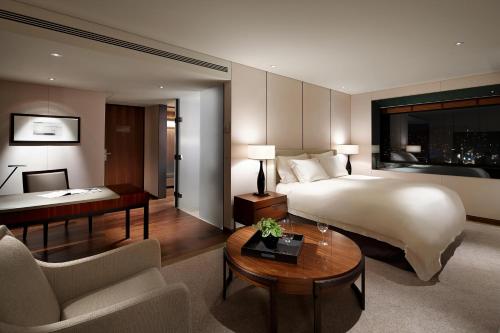 首尔首尔新罗酒店的大型酒店客房,配有一张床和一张书桌