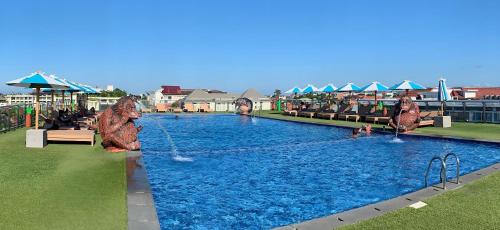 库塔苏利斯海滩spa酒店的度假村的游泳池,人们在里面玩耍