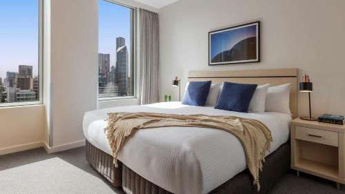 墨尔本Oaks Melbourne on Market Hotel的一间卧室设有一张大床和大窗户