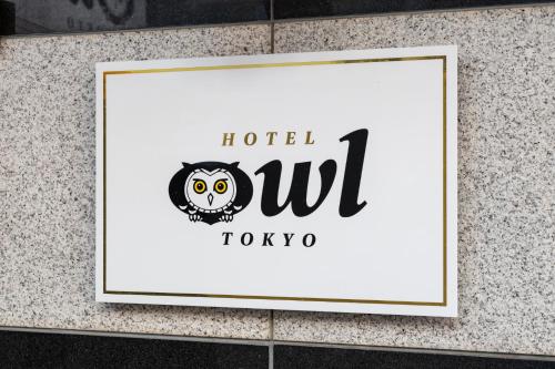 东京东京日暮里奥维力胶囊旅馆的墙上的标牌上挂着猫头鹰