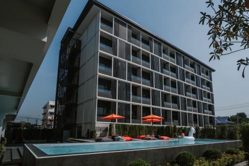 曼谷The Iconic Hotel Don Mueang Airport的大楼前有游泳池的酒店