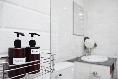 清迈B and Y Residence的浴室设有水槽和2瓶洗发水。