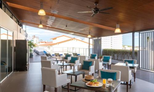 芭堤雅市中心Travelodge Pattaya的阳台餐厅,配有桌椅