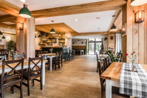 扎科帕内太阳神酒店的餐厅铺有木地板,配有桌椅