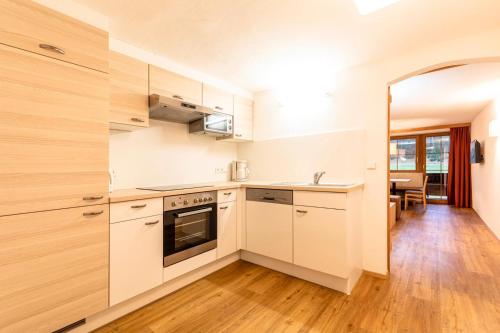 阿亨基希施兰巴赫霍夫公寓的厨房铺有木地板,配有白色橱柜。