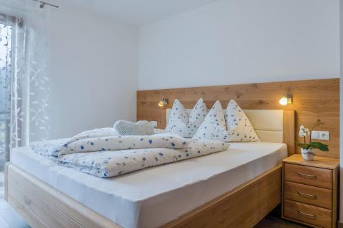 圣马蒂诺Hofschenke Pfeiftal - Bergblick的卧室配有带蓝色枕头的大型白色床