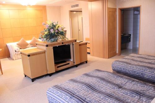 白山市白山格兰德酒店的一间酒店客房,设有两张床和电视