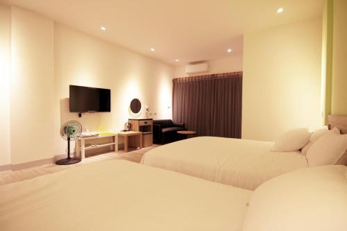 东港海津&海町文旅的酒店客房设有两张床和一台平面电视。