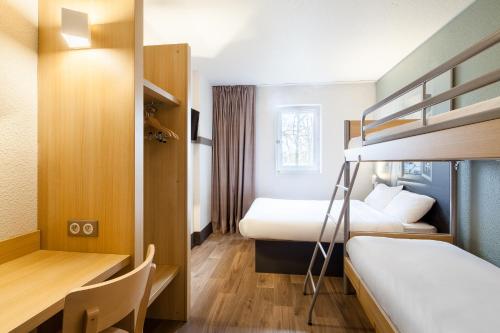 奥尔日河畔圣米歇尔B&B HOTEL Saint-Michel sur Orge的酒店客房配有两张床和一张书桌