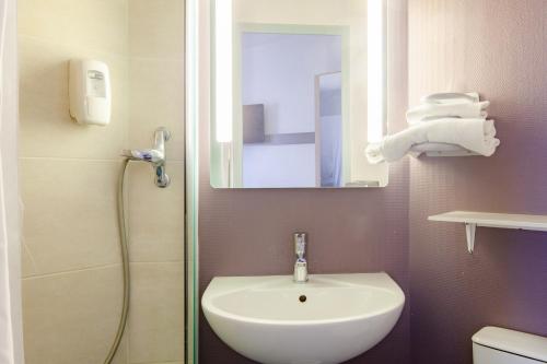 奥尔日河畔圣米歇尔B&B HOTEL Saint-Michel sur Orge的浴室配有盥洗盆和带镜子的淋浴