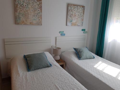 卡萨雷斯Meerblick Casares del Sol的卧室内的两张床,配有绿色窗帘