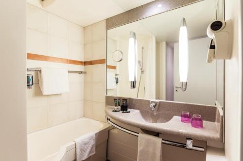 杜塞尔多夫杜塞尔多夫城西诺沃特酒店的浴室配有盥洗盆、浴缸和盥洗盆