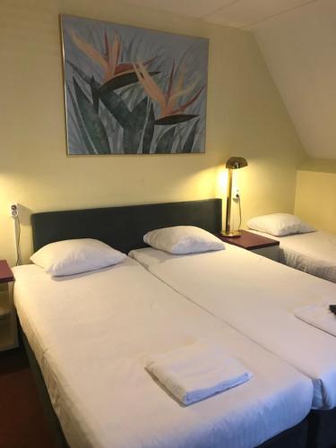 桑特普尔特北维曼酒店的两张位于酒店客房的床,配有毛巾